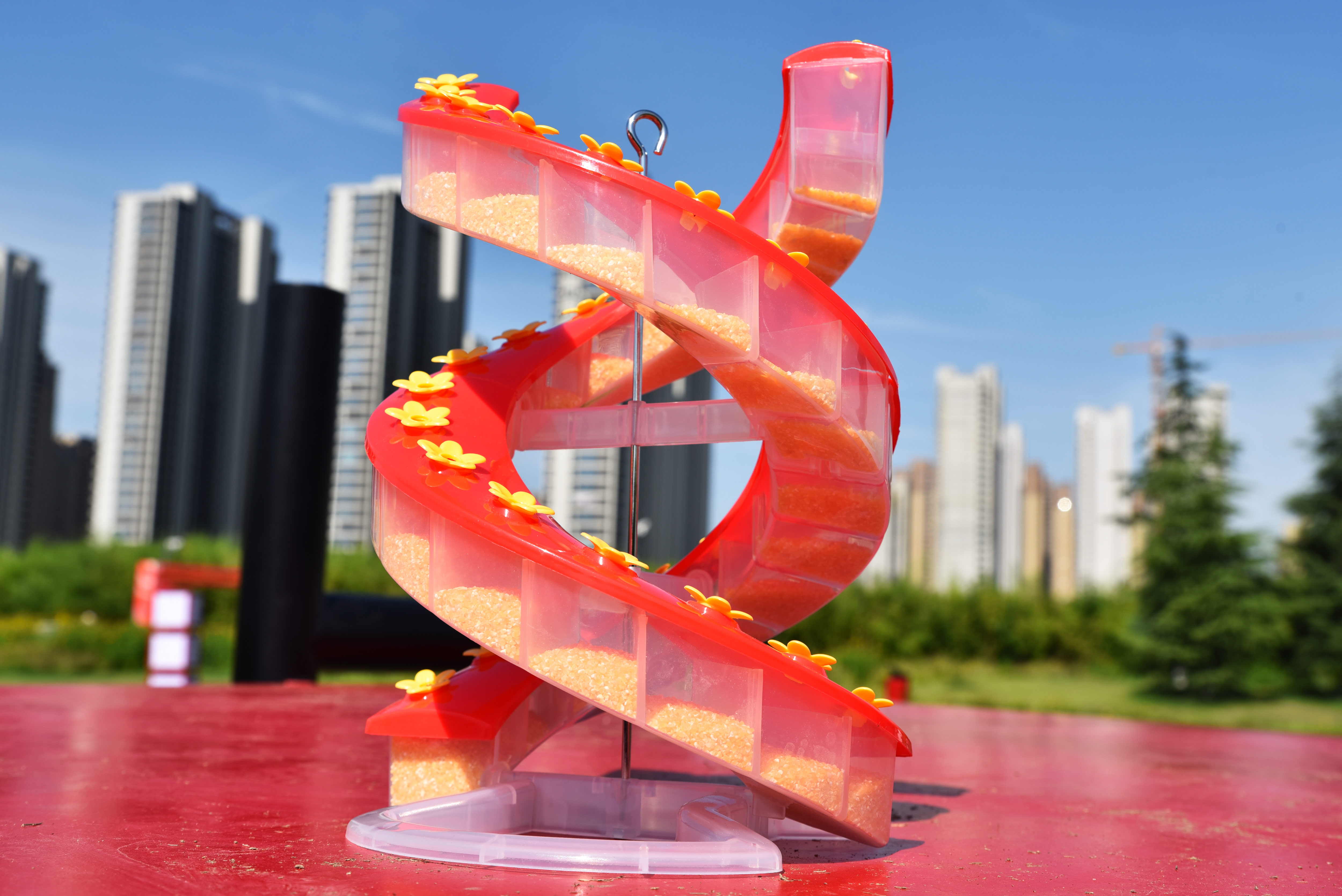 Sherem DNA Helix Hummingbird Feeder, a red spiral feeder with clear nectar chambers and yellow flower ports